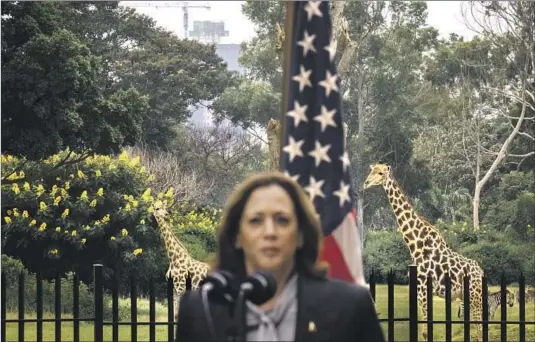  ?? Photograph­s by Kent Nishimura Los Angeles Times ?? GIRAFFES and zebras wander in the background as Vice President Kamala Harris holds a news conference March 31 at the State House in Lusaka, Zambia.