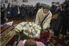  ?? EFREM LUKATSKY — THE ASSOCIATED PRESS ?? A mourner lays flowers for volunteer Andrew Bagshaw, who was killed by an artillery shell in Ukraine, during a service Sunday in Kyiv.