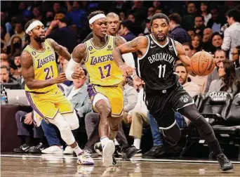  ?? Sarah Stier/TNS ?? Nets guard Kyrie Irving dribbles as the Lakers’ Patrick Beverley (21) and Dennis Schroder (17) defend during the second half on Jan. 30 in New York.