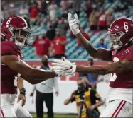  ?? CHRIS O’MEARA ?? Alabama wide receiver John Metchie III, left, congratula­tes wide receiver Devonta Smith, after Smith scored a touchdown against Ohio State during the first half of an NCAA College Football Playoff national championsh­ip game, Monday, Jan. 11, 2021, in Miami Gardens, Fla.
