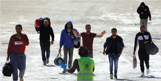  ?? (Mussa Qawasma/Reuters) ?? PALESTINIA­N WORKERS returning from Israel arrive at a coronaviru­s testing site, outside the Tarkumiya checkpoint near Hebron last week.