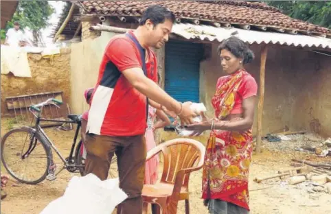  ?? HT PHOTO ?? Mangesh Jha hands over sanitary napkins to a woman at Jonha village in Ranchi.