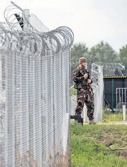  ??  ?? Ein ungarische­r Soldat bewacht die Transitzon­e an der Grenze zu Serbien. Budapest fordert von der EU eine Kostenbete­iligung bei den Grenzschut­zanlagen – Flüchtling­e will es aber nicht aufnehmen.