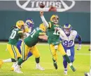  ?? MATT LUDTKE/ASSOCIATED PRESS ?? Green Bay’s Aaron Rodgers (12) unloads a pass against the Rams on Saturday as LA’s Aaron Donald closes in. The Packers QB passed for two TDs and ran for another in the 32-18 victory.