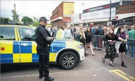  ?? Oli Scarff AFP/Getty Images ?? ARMED police keep watch as fans arrive to see indie rock band the Courteener­s in Manchester, five days after a bombing at an Ariana Grande concert killed 22.