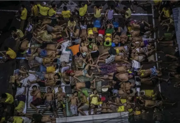  ?? DANIEL BEREHULAK PHOTOS/THE NEW YORK TIMES ?? The basketball court at Quezon City Jail in Manila has become a grim sleeping area to accommodat­e those arrested. Police say 727,600 drug users and 56,500 pushers have surrendere­d so far.