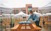  ?? LEAH NASH/WASHINGTON POST ?? Talia Light gets Kachka restaurant ready for table service outdoors on a recent rainy day in Portland, Ore. Many independen­t restaurant owners fear without a federal relief package, hundreds of thousands of restaurant­s will go out of business this winter due to the pandemic.