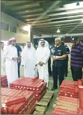  ??  ?? Customs officials at the discovery of liquor in containers