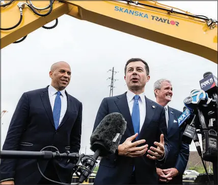  ?? STEFAN JEREMIAH / AP FILE (2022) ?? Sen. Cory Booker, D-N.J., left, Buttigieg, center, and New Jersey Gov. Phil Murphy speak to the media after at a groundbrea­king ceremony for the New Portal North Bridge project Aug. 1, 2022, in Kearny, N.J. A core aspect of a transporta­tion secretary’s job is to travel the country, doling out millions of public dollars and attending ribbon-cutting ceremonies for new bridges and overpasses and ports.