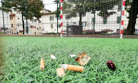  ??  ?? La serratura del lucchetto manomessa con la colla per non consentire agli addetti di chiudere a chiave il cancello del campetto di piazza Tasso Mozziconi e tracce di spinelli sul campo in erba sintetica di piazza Tasso Ogni notte, anche fino all’alba, gruppi di giovani riescono a varcare il cancello e tengono sveglia l’intera piazza con urla e musica a volume alto