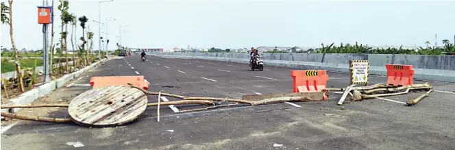  ?? GALIH ADI/JAWA POS ?? CEGAH KRIMINALIT­AS: Petugas gabungan Kecamatan Bulak memasang water barrier dan kayu untuk menutup JLLT zona 1 kemarin. Kawasan itu sering menjadi tempat balapan sepeda motor.