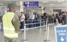  ?? — Reuters ?? Travellers queue to be screened after the Kenya Airports Authority installed health devices to screen for Ebola at the Jomo Kenyatta airport in Nairobi.