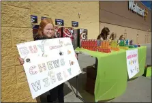  ?? NWA Democrat-Gazette/BEN GOFF @NWABENGOFF ?? Emily Starkey (from left), Emma Griggs, Caroline Barnett and Olivia Tingley with Girl Scout Brownie Troop 5343 sell cookies in a booth at the Walmart Supercente­r on Elm Springs Road in Springdale. The troop earns about 55 cents per box of cookies sold...