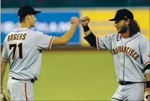  ?? DAVID J. PHILLIP — THE ASSOCIATED PRESS ?? Tyler Rogers celebrates with Brandon Crawford after the Giants defeated the Houston Astros 7-6 in 10 innings on Tuesday in Houston. San Francisco is a surprising 8-12.