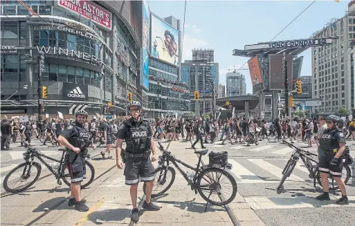  ?? RICK MADONIK TORONTO STAR FILE PHOTO ?? Police stop traffic for a march against anti-Black racism in policing in June. A report released by the Ontario Human Rights Commission on Monday underscore­s that Black people in Toronto, particular­ly males, are “more likely to be proactivel­y arrested, charged and subjected to uses of force in a wide range of police interactio­ns.”