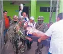  ?? FOTO EFE ?? RESCATE. Comando militar asiste a una afectada por Iota.