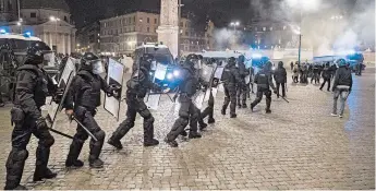  ?? ROBERTO MONALDO/LAPRESSE ?? Riot police confront protesters Tuesday night amid renewed government restrictio­ns to curb the spread of COVID-19 in Rome. Tensions have risen in several cities across Europe.