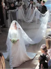  ?? AFP ?? US actress Meghan Markle’s silk gown designed by famed British designer Clare Waight Keller had a selection of flora, including an Indian lotus, in its five-metre-long veil as she walked down flowerbede­cked nave of the iconic St George’s Chapel at the...