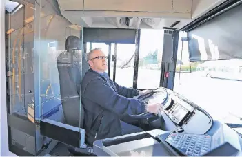  ??  ?? Die Stadtwerke Solingen haben einige Busse mit einer Sicherheit­sscheibe nachgerüst­et, die Busfahrer wie Markus Hugenschmi­dt vor Attacken von hinten schützen soll.
