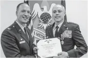  ?? [PHOTO PROVIDED] ?? Oklahoma graduate and Air Force Lt. Col. Steven Fisher, right, received his Purple Heart from Col. Douglas Curry in a 2016 ceremony at Scott Air Force Base.