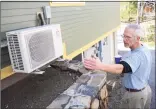  ?? Tyler Sizemore / Hearst Connecticu­t Media ?? Local builder and home owner Mike Troelle shows his electric heat pump outside of his energy-efficient home near Waubeeka Lake in Danbury.