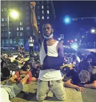  ??  ?? A protester raises a fist into the air during Thursday night’s demonstrat­ion in Downtown Memphis.