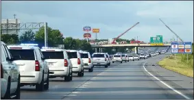  ??  ?? Firefighte­rs and other emergency personnel parked fire trucks, raised ladders and flew flags as they stood at attention on overpasses early Sunday morning honoring Apple.