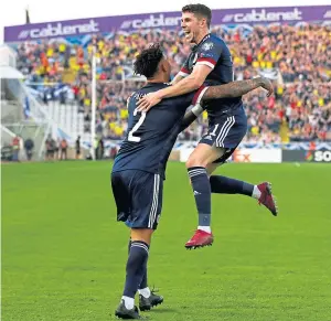  ??  ?? Top: John Mcginn slots home Greg Taylor’s cross to restore Scotland’s lead; above: Ryan Christie celebrates his opener with Liam Palmer; left: captain Steven Naismith and Ioannis Kousoulos battle for the ball. PA.