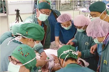  ??  ?? SEPARATING TWINS — The team of Taiwanese doctors carefully works on the separation of 15-month-old conjoined twins, Jennelyn and Jerrelyn de Guzman of Bautista, Pangasinan, in an eight-hour surgerical operation last Saturday at the Buddhist Tzu Chi...