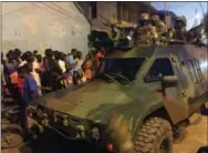  ?? THE ASSOCIATED PRESS ?? ECOWAS Senegalese troops hold their position near to the presidenti­al palace in the Gambian capital Banjul on Sunday, one day after Gambia’s defeated leader Yahya Jammeh left the country into exile.