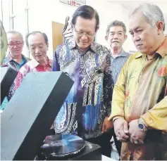  ??  ?? Lee (second right) and others enjoying the sound of English oldies being played on an antique gramophone at the exhibition.