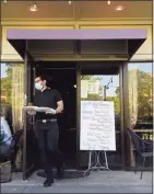  ??  ?? Erik Taylor brings food to an outdoor table at La Piccolina restaurant in New Milford last May. Outdoor dining will continue in town again this summer.