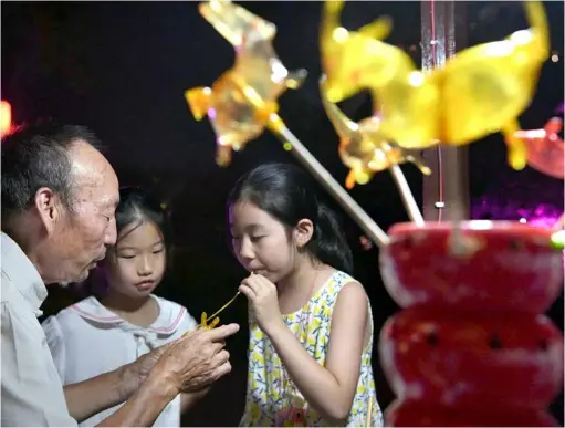  ?? VNA Photo
XINHUA/ ?? LIFE IS SWEET: A child tries sugarfigur­ine blowing at Luoyi ancient town in Luoyang, central China's Henan Province.