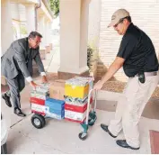  ??  ?? City Manager Guy Henson, left, and Shane Barnard, with Midwest City Neighborho­od Services, deliver school supplies to Tinker Elementary School as part of Midwest City’s Support Our Schools project.