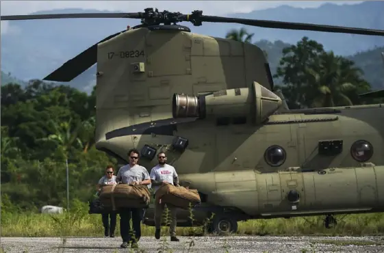  ?? Fernando Llano/Associated Press ?? Team Rubicon’s disaster response members on Thursday unload aid at the airport to take to the hospital where they are treating residents injured in Saturday’s 7.2 magnitude earthquake in Les Cayes, Haiti.