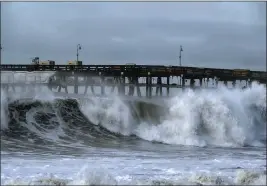  ?? RICHARD VOGEL — THE ASSOCIATED PRESS ?? Large waves crash along the Southern California coast near the Ventura Pier in Ventura on Dec. 30. Since the Gold Rush, California's coast has been dotted by piers that have gone from serving steamships to becoming an integral part of many beach towns' identities, but rising seas and frequent storms are threatenin­g the iconic structures.