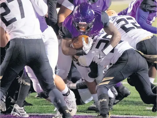  ?? KYLE TELECHAN/POST-TRIBUNE PHOTOS ?? Merrillvil­le’s Lavarion Logan pushes through the Penn defense into the end zone for his record-breaking touchdown in a Class 6A regional Friday.