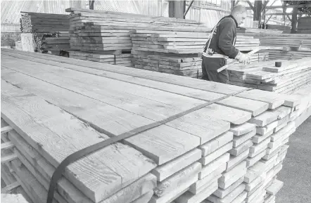  ?? PAUL CHIASSON, THE CANADIAN PRESS ?? A worker tidies up stacks of lumber at a building supply store in Montreal.