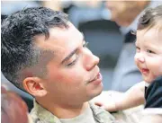  ??  ?? Left, Spc. Marcus Martinez with his son, “Little Marcus” Martinez, 8 months, are shown after Sunday’s departure ceremony for the 1345 Transporta­tion Company, 90th Troop Command, Oklahoma Army National Guard. The unit are deploying to Southwest Asia in...