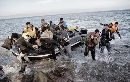  ??  ?? LESBOS: Refugees and migrants jump off a dinghy upon their arrival on the Greek island of Lesbos after crossing the Aegean Sea from Turkey yesterday. —AFP
ISTANBUL: