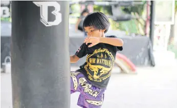  ??  ?? GETTING HER KICKS: A girl trainee practises at the gym. She is trained by Boom.