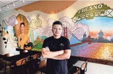  ?? AP/RICHARD VOGEL ?? David Rasavong stands by a mural depicting his family’s journey from Laos to San Francisco and then to Fresno, in his restaurant Love & Thai.