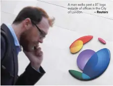  ?? — Reuters ?? A man walks past a BT logo outside of offices in the City of London.