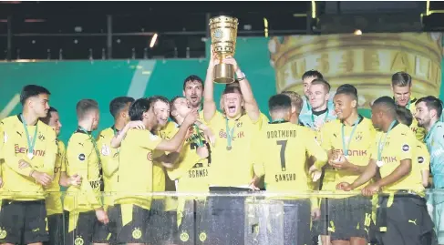  ?? — Gambar AFP ?? RAIKAN BERSAMA: Pemain pasukan Borussia Dortmund meraikan kejayaan di atas pentas selepas dinobatkan juara Kejohanan Piala Jerman dengan menewaskan RB Leipzig 4-1 pada perlawanan akhir di Berlin.