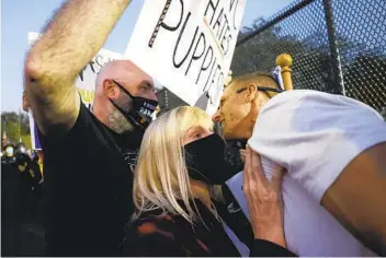  ?? JEFF SWINGER AP ?? A supporter of former Vice President Joe Biden (left) and a supporter of President Donald Trump clash during a rally outside the vice presidenti­al debate Wednesday in Salt Lake City.