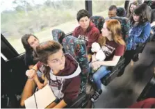  ?? THE ASSOCIATED PRESS ?? Julia Salomone, 18, front row left, Lindsey Salomone, 15, front row right, Jose Iglesias, 17, second row left, and Isabelle Robinson, 17, second row right, and other student survivors from Marjory Stoneman Douglas High School, talk on their bus Tuesday...