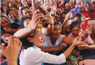  ??  ?? SELFIE BREAK
Sen. Grace Poe takes time to have a selfie with residents of Pinamalaya­n town in Oriental Mindoro.
Mayor Maynila? [I will have my neck cut before I sell, before it happens. I have not sold even a small lot owned by the Manila government....