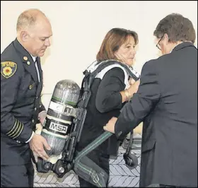  ?? LYNN CURWIN/TRURO NEWS ?? North River and District Deputy Fire Chief Guy Gallant, left, and Municipal Affairs Minister Chuck Porter help Colchester North MLA Karen Casey check out some of the firefighti­ng equipment. They were at the fire hall for an announceme­nt on grants to emergency service providers.