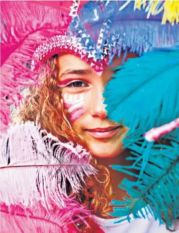  ??  ?? A girl smiles through her elaborate feathered headdress during the Notting Hill Carnival in west London. The weather cooled after the recent humid conditions for the first day of celebratio­ns, which is marked by colourful children’s parades