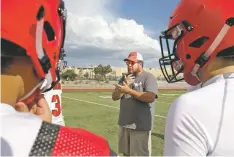  ??  ?? New Mexico School for the Deaf coach James Litchfield III talks with his team. The six-man football team has 14 players and will have three road trips this season to play out-of-state teams.